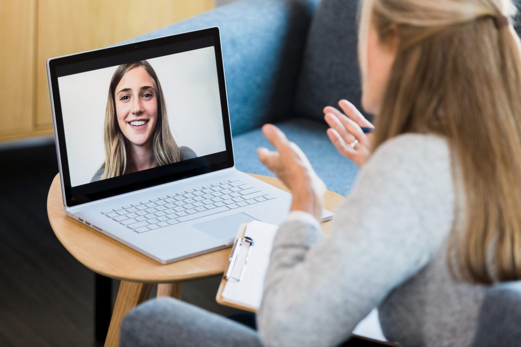 a female counselor gestures while talking with a young woman during a virtual therapy session stockpack gettyimages scaled 1